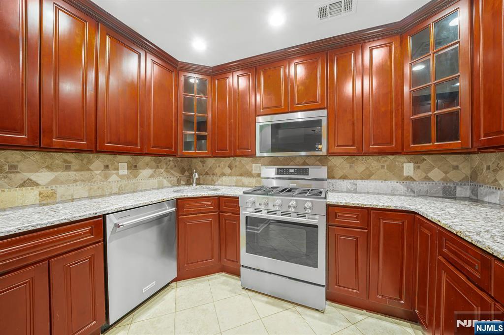 67 Davenport Road Montville, NJ 07045 - Photo 7 of 32 a kitchen with stainless steel appliances granite countertop wooden cabinets a stove top oven a sink and dishwasher