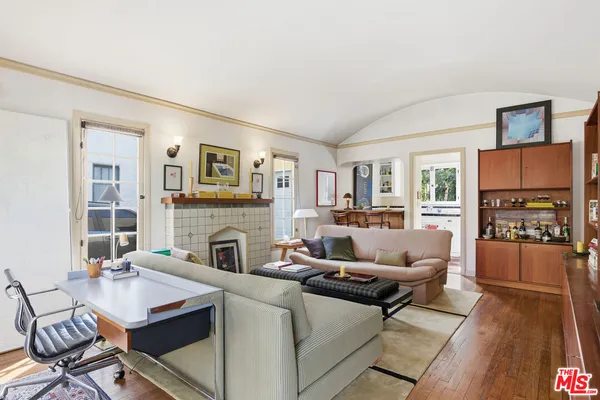 a living room with furniture a fireplace and a large window