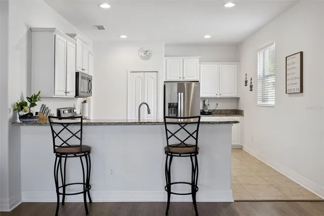 a kitchen with stainless steel appliances a refrigerator and microwave