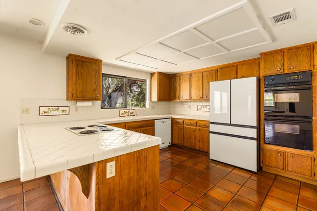 a kitchen with stainless steel appliances a refrigerator sink and cabinets