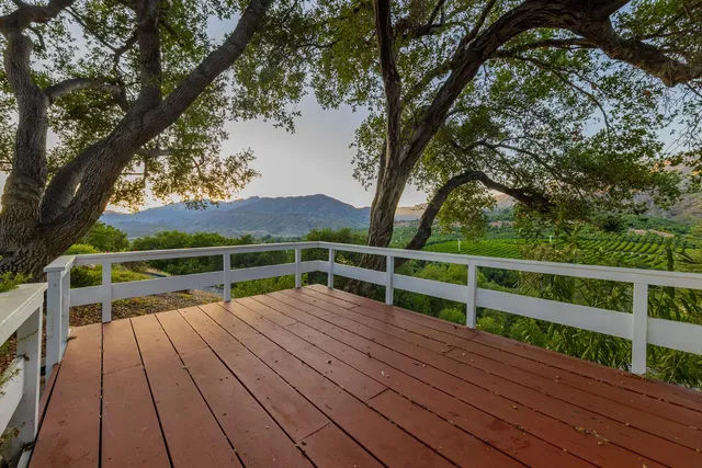 a view of balcony with wooden floor and fence