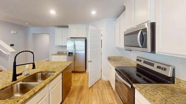 a bathroom with a granite countertop sink a toilet and shower