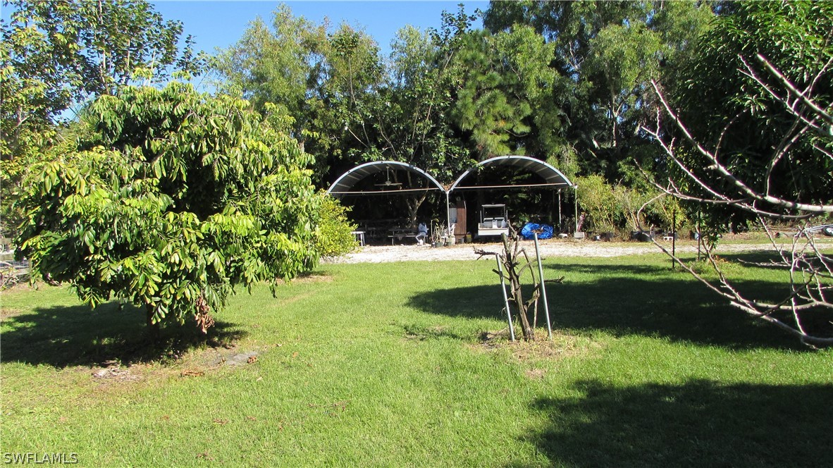 8390 Stringfellow Road St. James City, FL 33956 - Photo 8 of 35 a view of a garden with a bench