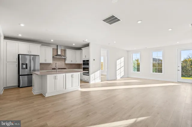 a large kitchen with white cabinets and stainless steel appliances