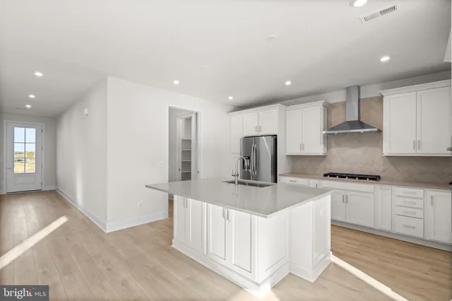 a kitchen with stainless steel appliances granite countertop a stove a sink and a refrigerator