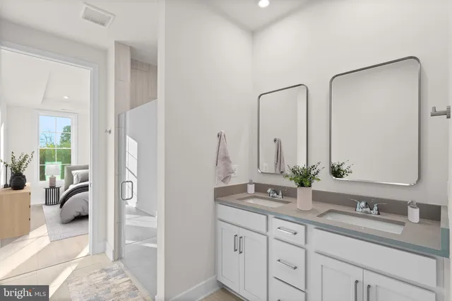 a en suite bathroom with a double vanity sink and a mirror
