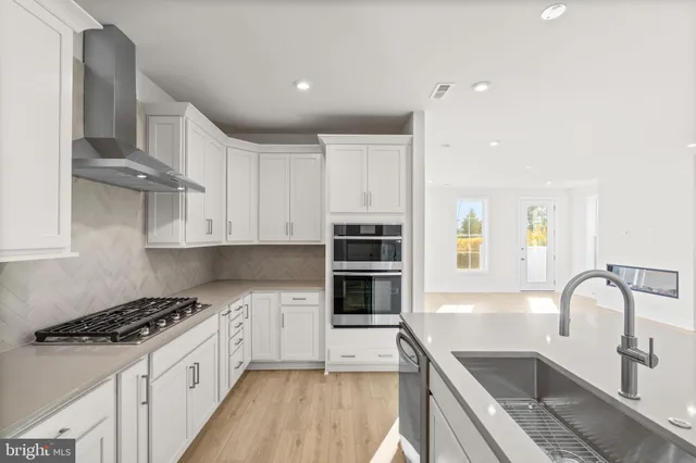 a kitchen with stainless steel appliances granite countertop a stove and a sink