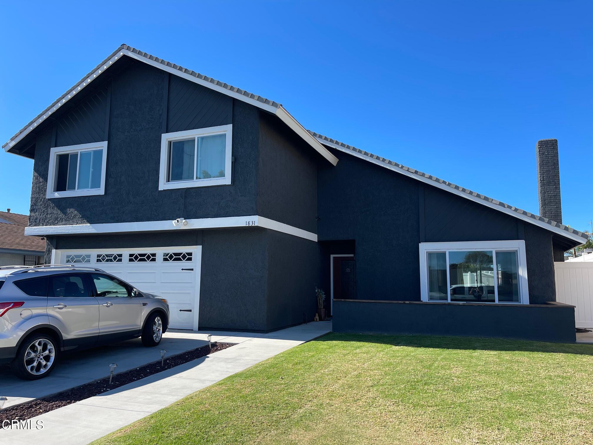 a car parked in front of a house with yard