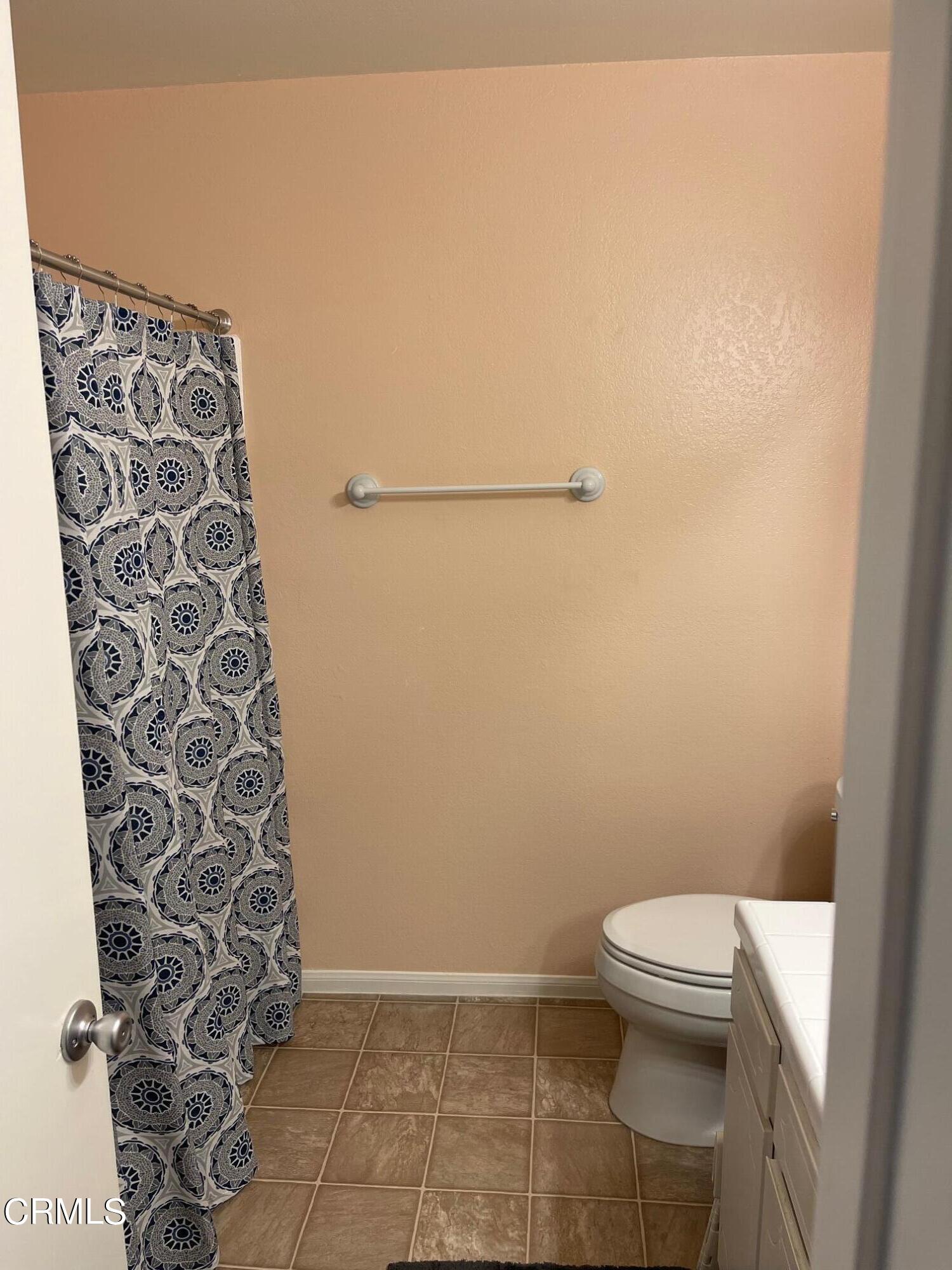 1831 Jetty Street Oxnard, CA 93035 - Photo 12 of 20 a bathroom with a toilet and a shower curtain