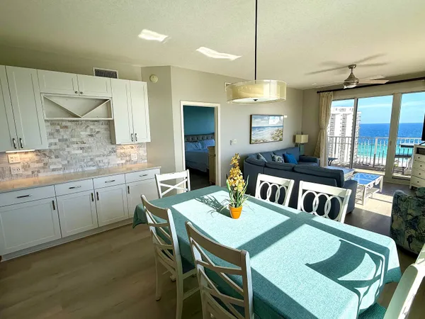 a kitchen with a dining table chairs and white cabinets