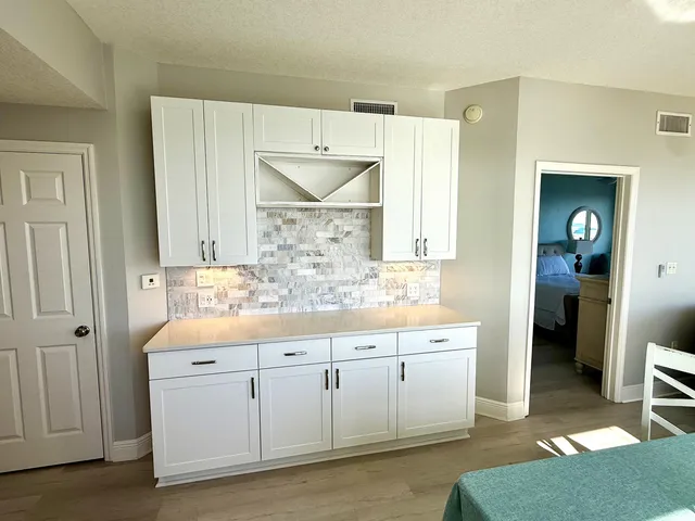 a kitchen with white cabinets a sink a window and stainless steel appliances