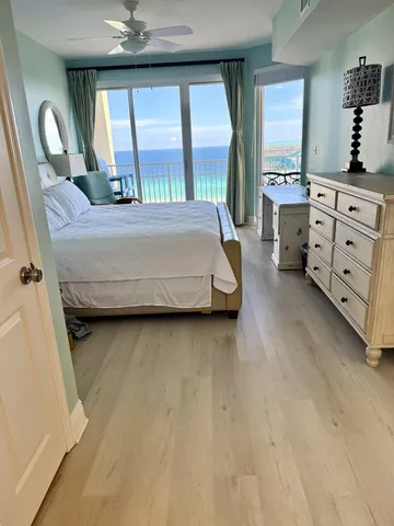 a bedroom with a bed next to a large window with the outer view