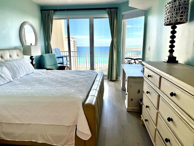 a spacious bedroom with a large bed and a chandelier