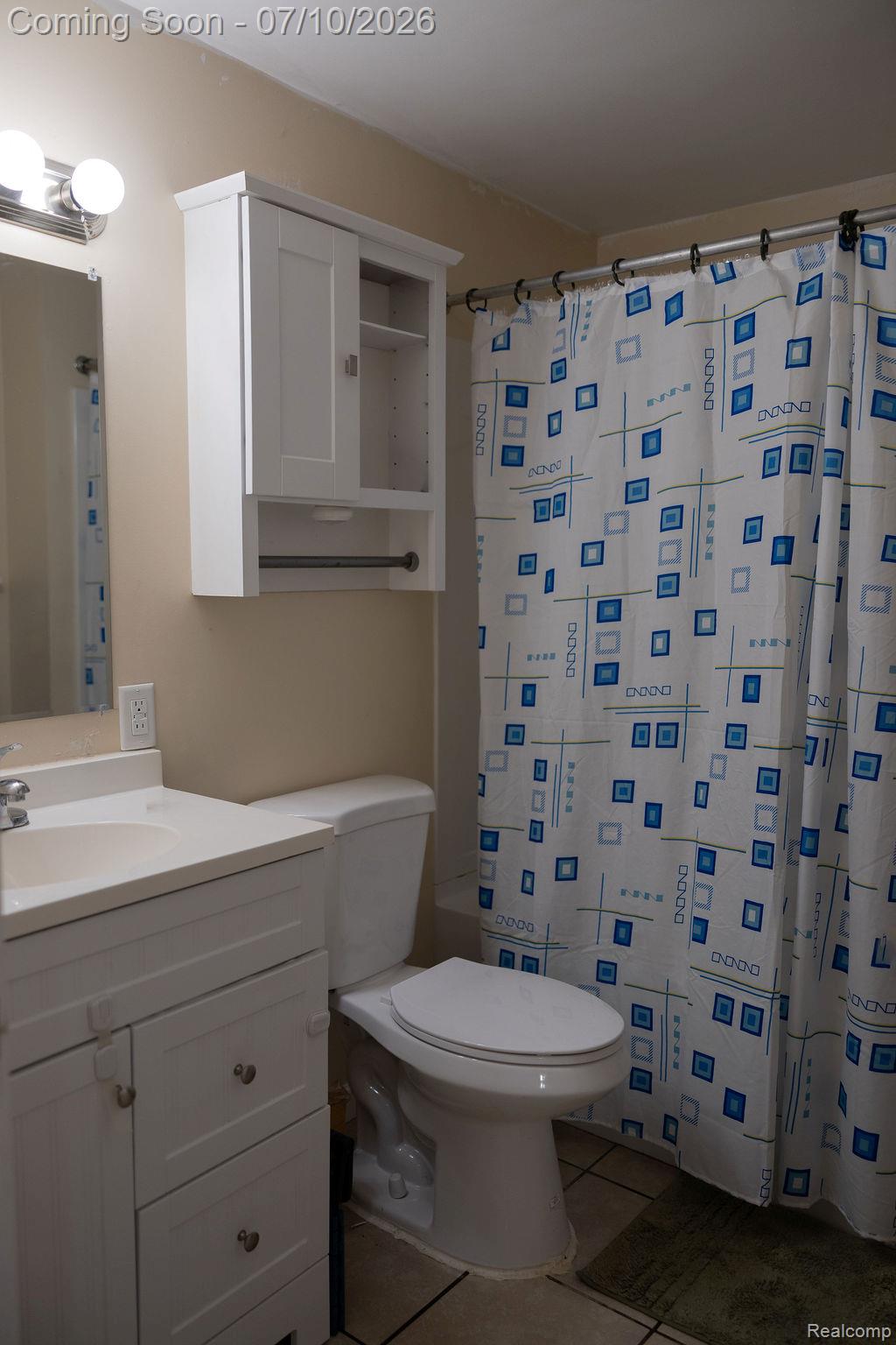 5052 Beecher Road Flint, MI 48532 - Photo 13 of 28 Bathroom featuring a white vanity with integrated sink, white toilet, and a wall-mounted medicine cabinet with a towel bar