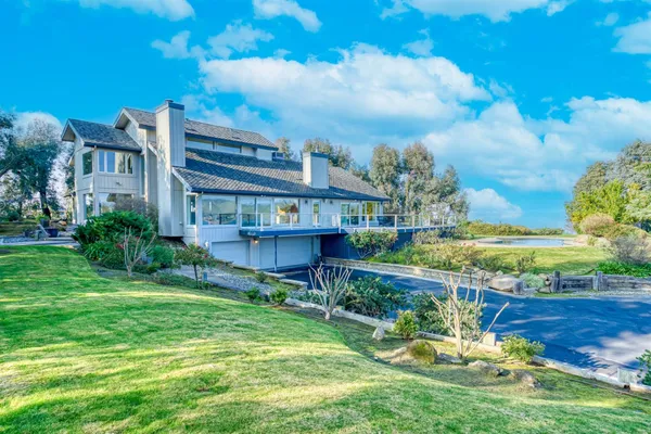 a view of a house with swimming pool and a yard