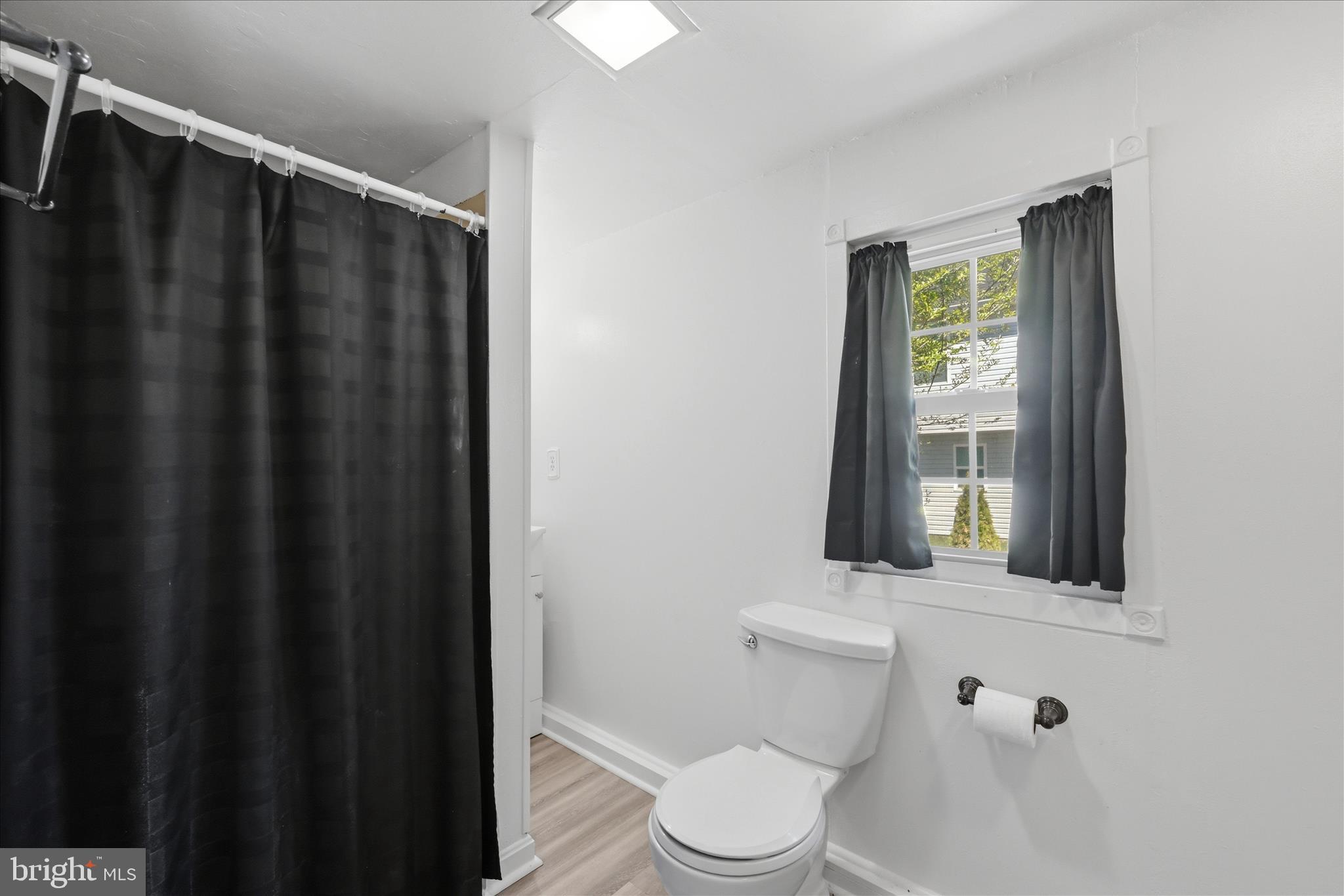 510 North Pleasant Valley Road Winchester, VA 22601 - Photo 29 of 63 a bathroom with a toilet a window and shower curtain