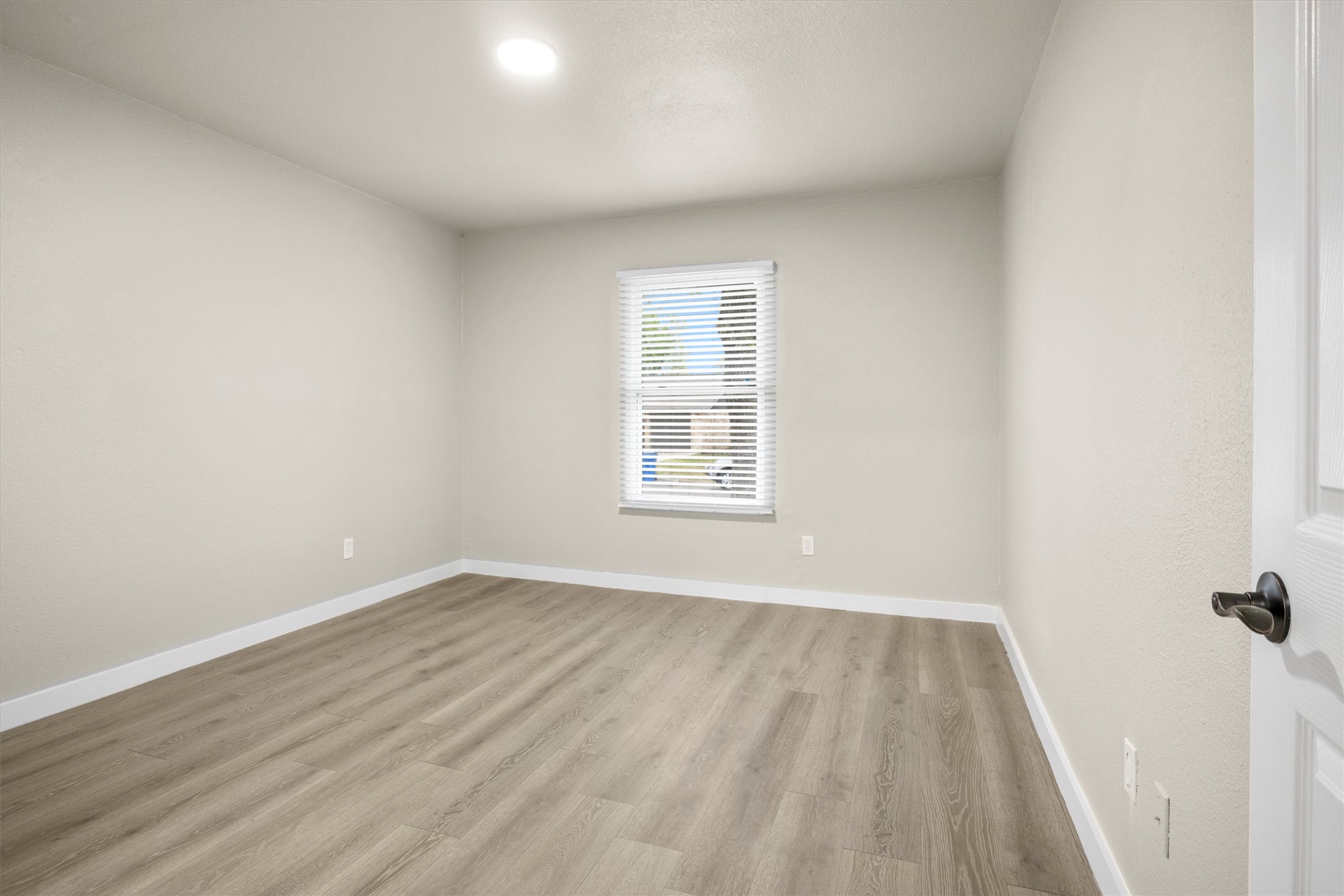 502 Pin Tail Lane Taylor, TX 76574 - Photo 10 of 26 Neutral-toned room featuring wood-finish flooring, white baseboards, and a single window with blinds