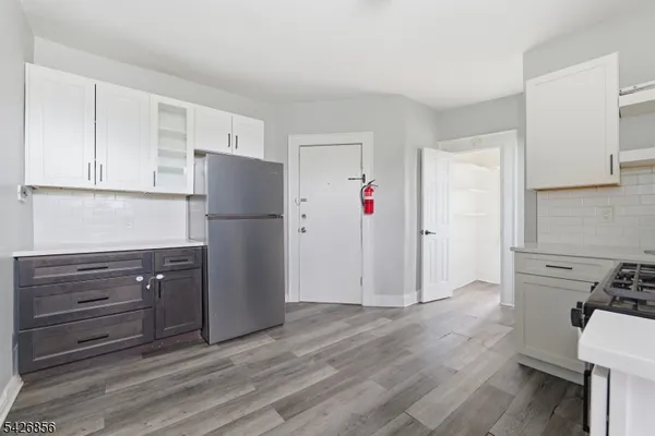 a kitchen with a refrigerator and a stove top oven