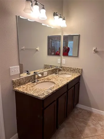 a bathroom with a granite countertop sink and a mirror