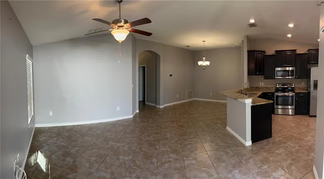 a view of kitchen with stainless steel appliances granite countertop cabinets and outdoor space