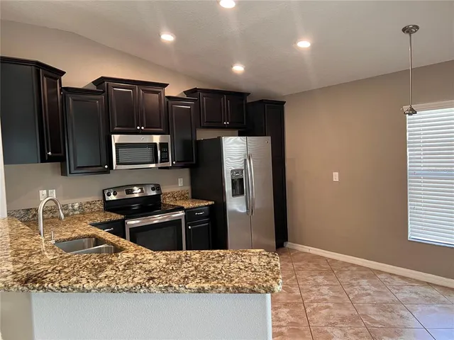 a kitchen with stainless steel appliances granite countertop a refrigerator and a sink