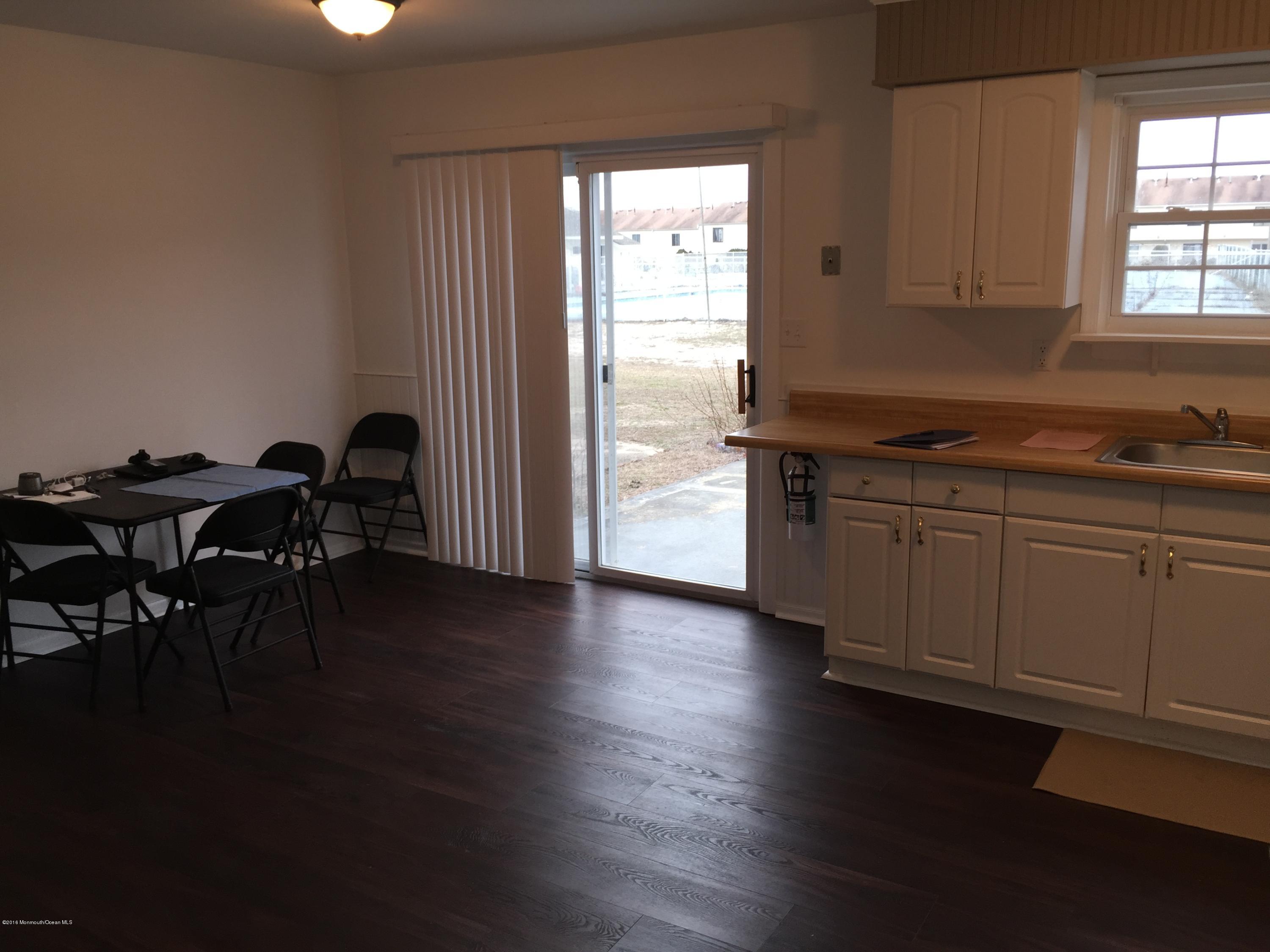 313 Sawmill Road, Unit 58 Brick, NJ 08724 - Photo 9 of 9 a kitchen with stainless steel appliances granite countertop a stove top oven a dining table and chairs with wooden floor