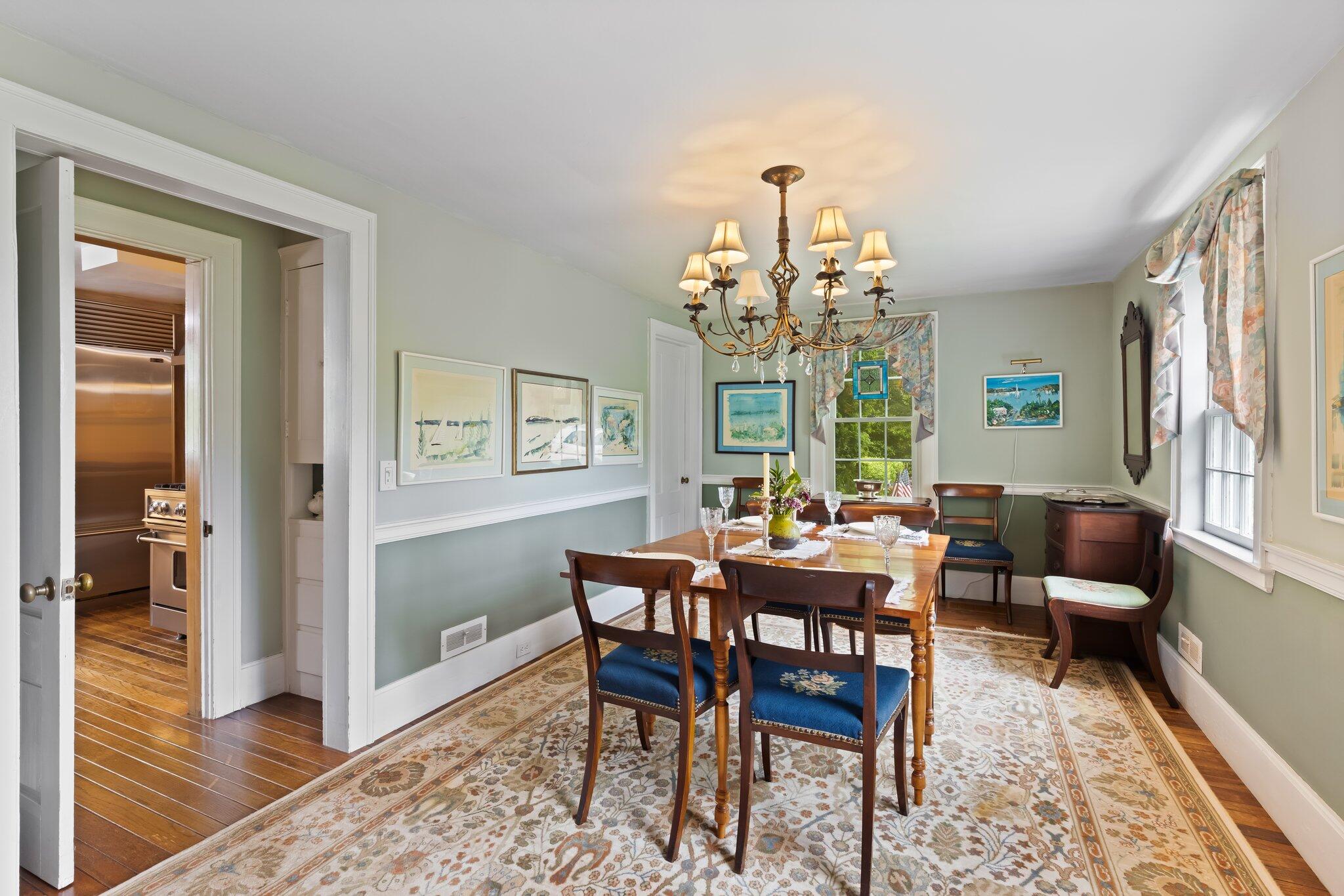 152 Monument Road Orleans, MA 02653 - Photo 12 of 40 a dining room with wooden floor a chandelier a wooden table and chairs