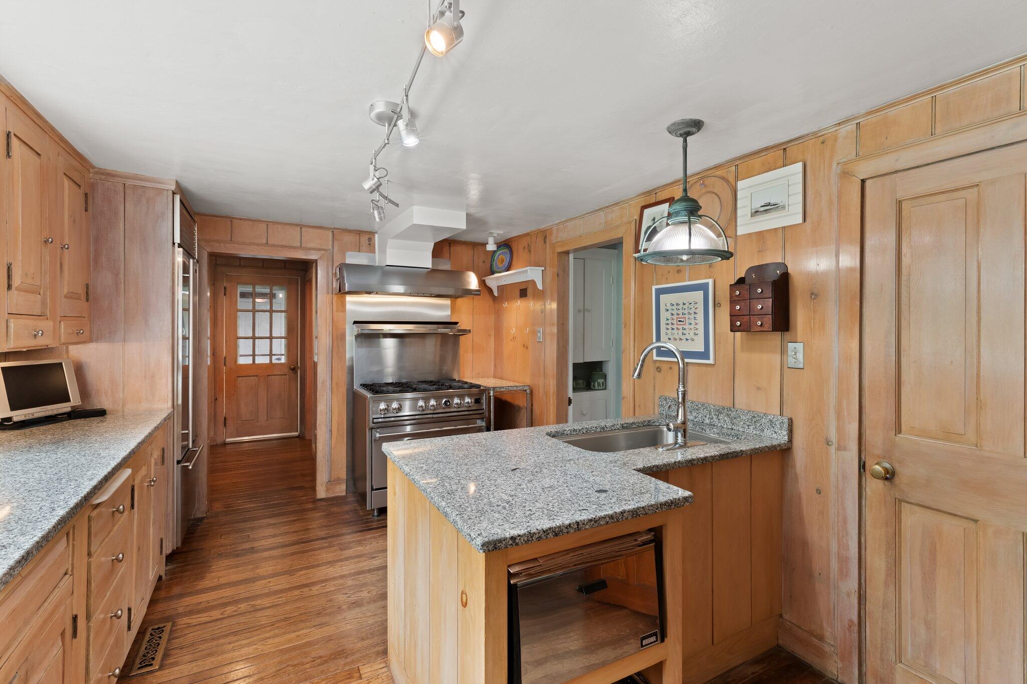 152 Monument Road Orleans, MA 02653 - Photo 13 of 40 a kitchen with granite countertop kitchen island stainless steel appliances a sink stove refrigerator and cabinets