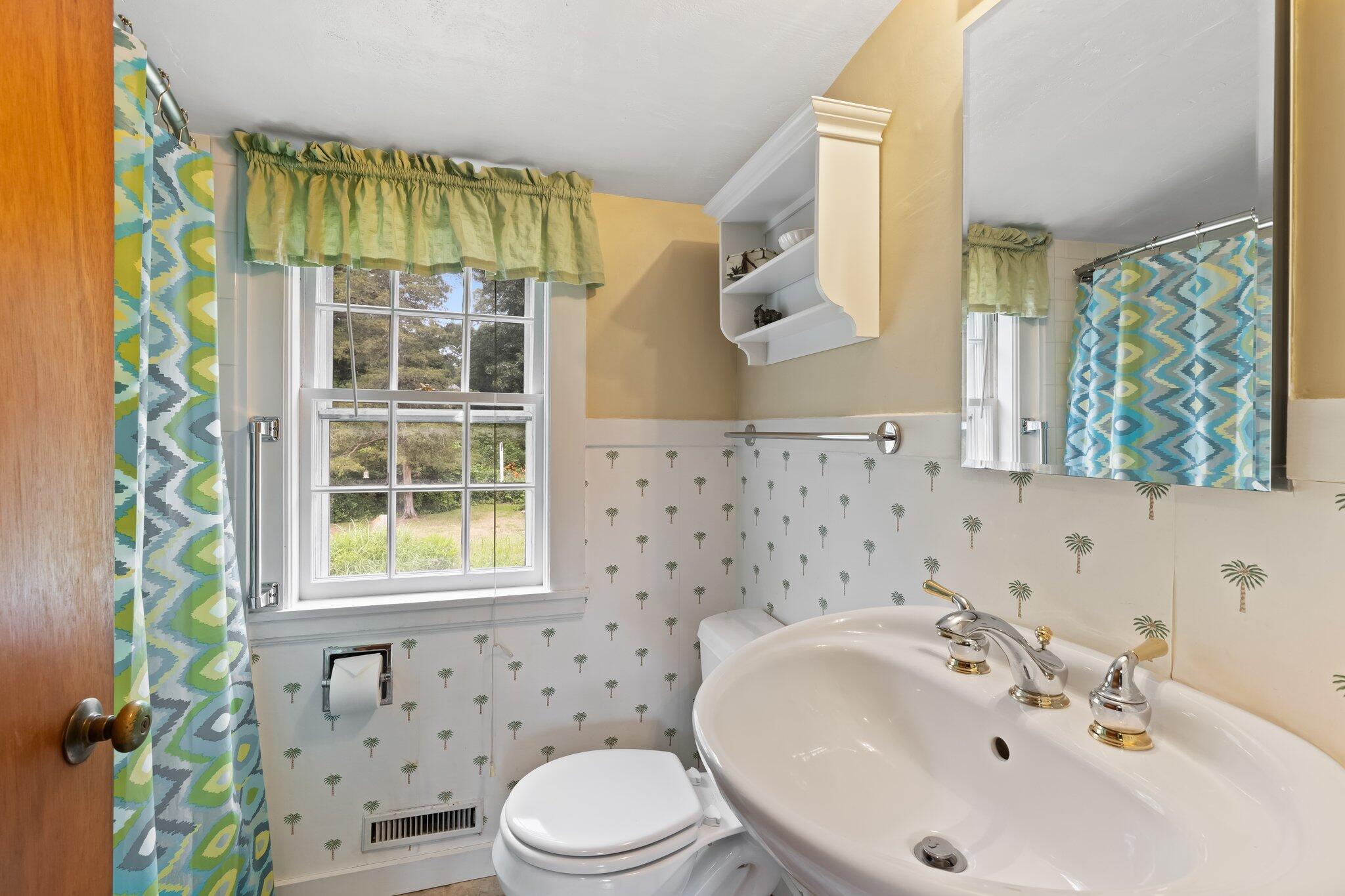 152 Monument Road Orleans, MA 02653 - Photo 27 of 40 a bathroom with a sink a toilet and shower curtain