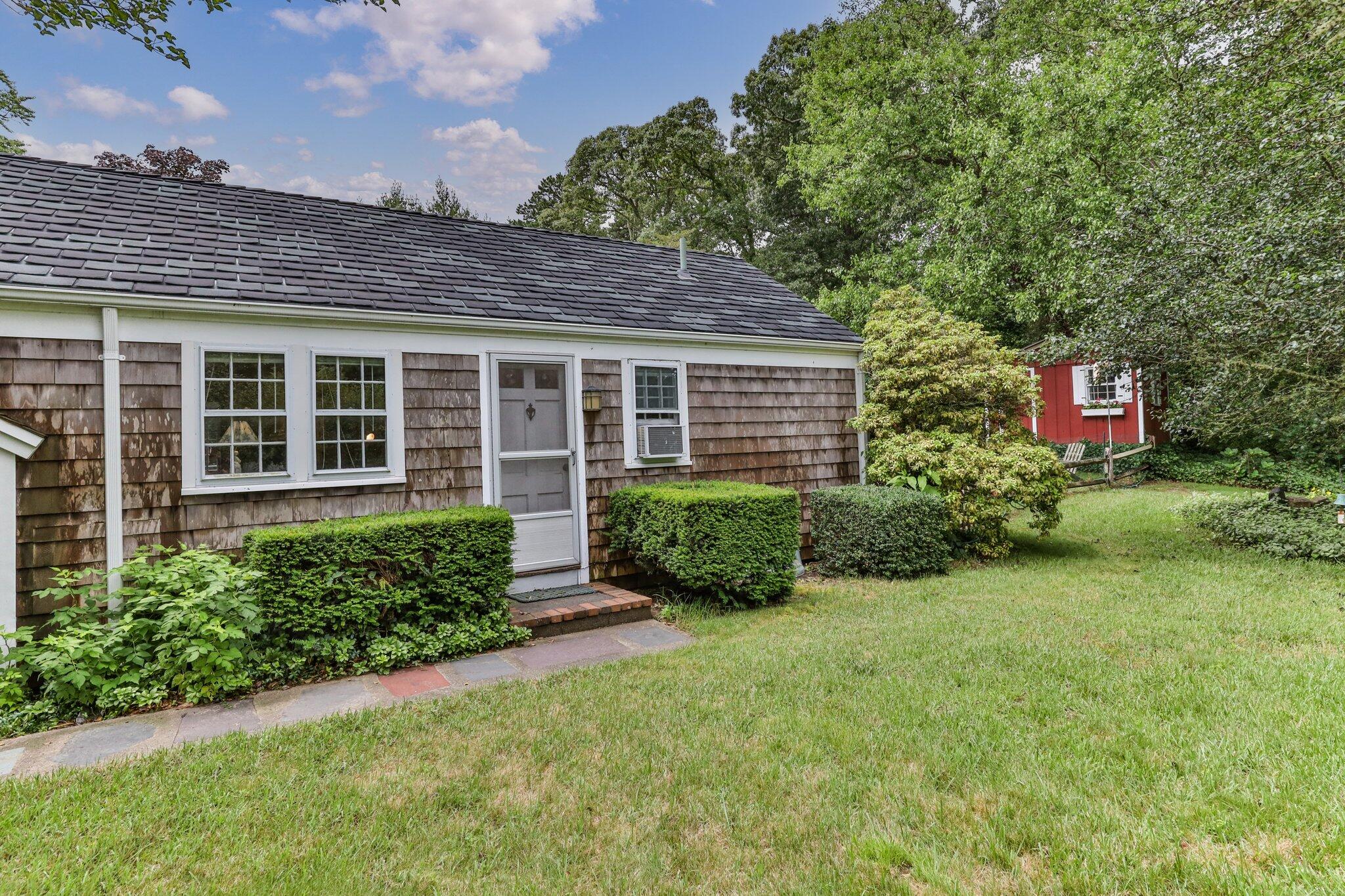 152 Monument Road Orleans, MA 02653 - Photo 7 of 40 a front view of a house with a yard and potted plants