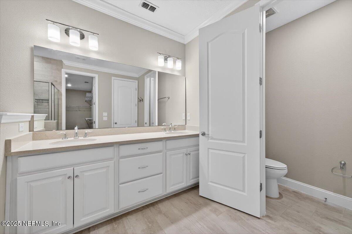 178 Antolin Way St. Augustine, FL 32095 - Photo 53 of 107 a bathroom with a double vanity sink a toilet and a mirror