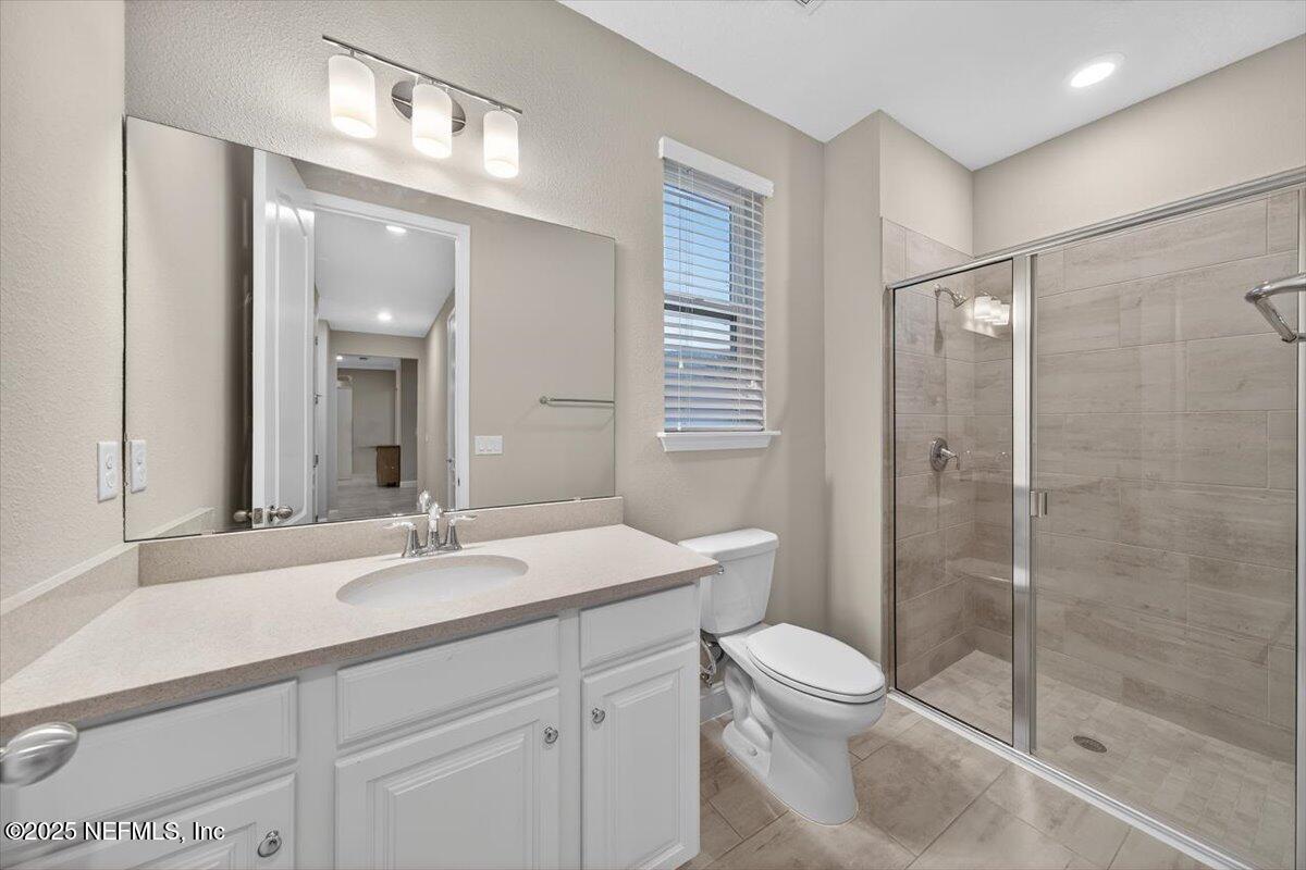 178 Antolin Way St. Augustine, FL 32095 - Photo 9 of 107 a bathroom with a toilet a sink a mirror a shower a vanity and window