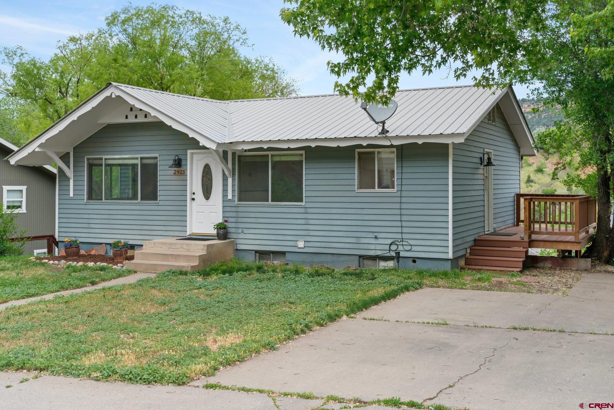 2913 Richard Drive Durango, CO 81301 - Photo 30 of 35 a view of a white house with a yard plants and large tree
