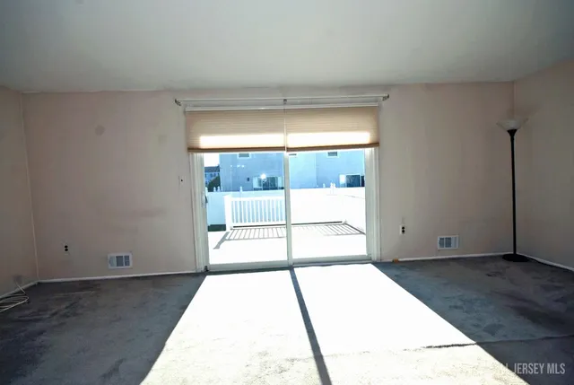 an empty room with wooden floor and chandelier