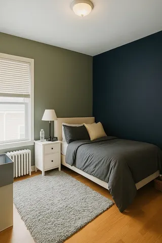 a bed sitting in a bedroom next to a window with lamp