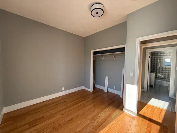 an empty room with wooden floor and entrance