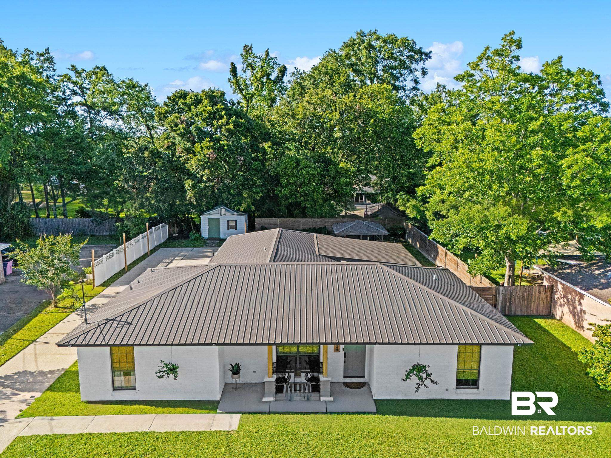 524 Ariel Avenue Foley, AL 36535 - Photo 2 of 37 Single-story residence featuring a gray metal roof, white brick exterior, and a concrete front porch