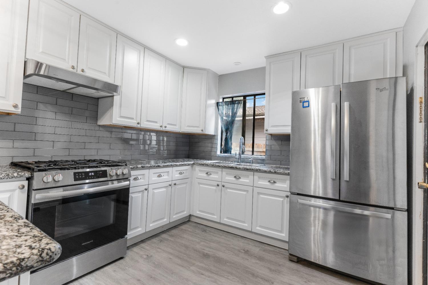232 Prospect Street Oak View, CA 93022 - Photo 8 of 33 a kitchen with cabinets stainless steel appliances a sink and wooden floor