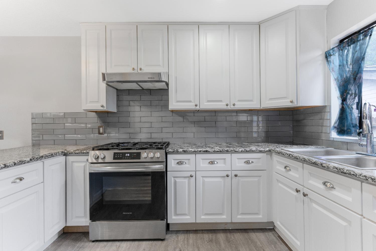232 Prospect Street Oak View, CA 93022 - Photo 9 of 33 a kitchen with granite countertop white cabinets and white stove