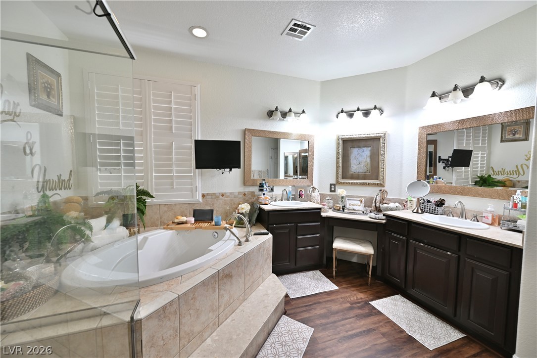 2729 Kildrummie Street Henderson, NV 89044 - Photo 8 of 42 Indulge in a tranquil primary bathroom retreat featuring a spacious soaking tub and dual vanities.