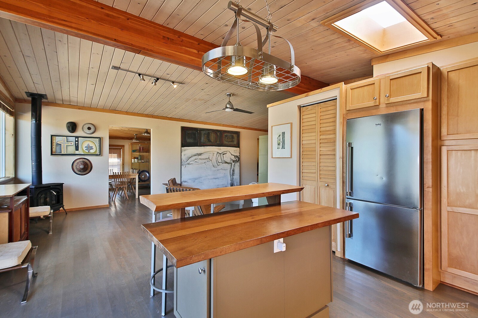 8121 Sandy Hook Terrace Clinton, WA 98236 - Photo 11 of 40 a view of a kitchen with stainless steel appliances granite countertop a refrigerator a stove and a dining table with wooden floor