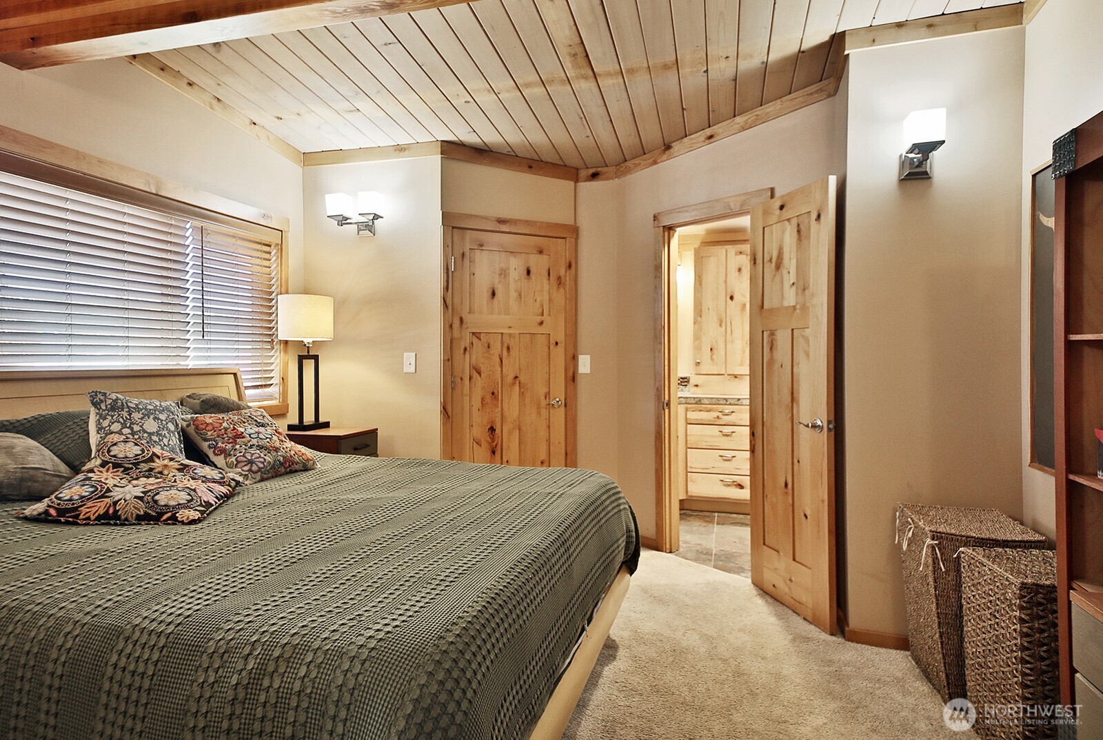 8121 Sandy Hook Terrace Clinton, WA 98236 - Photo 17 of 40 a bedroom with a bed and a chandelier