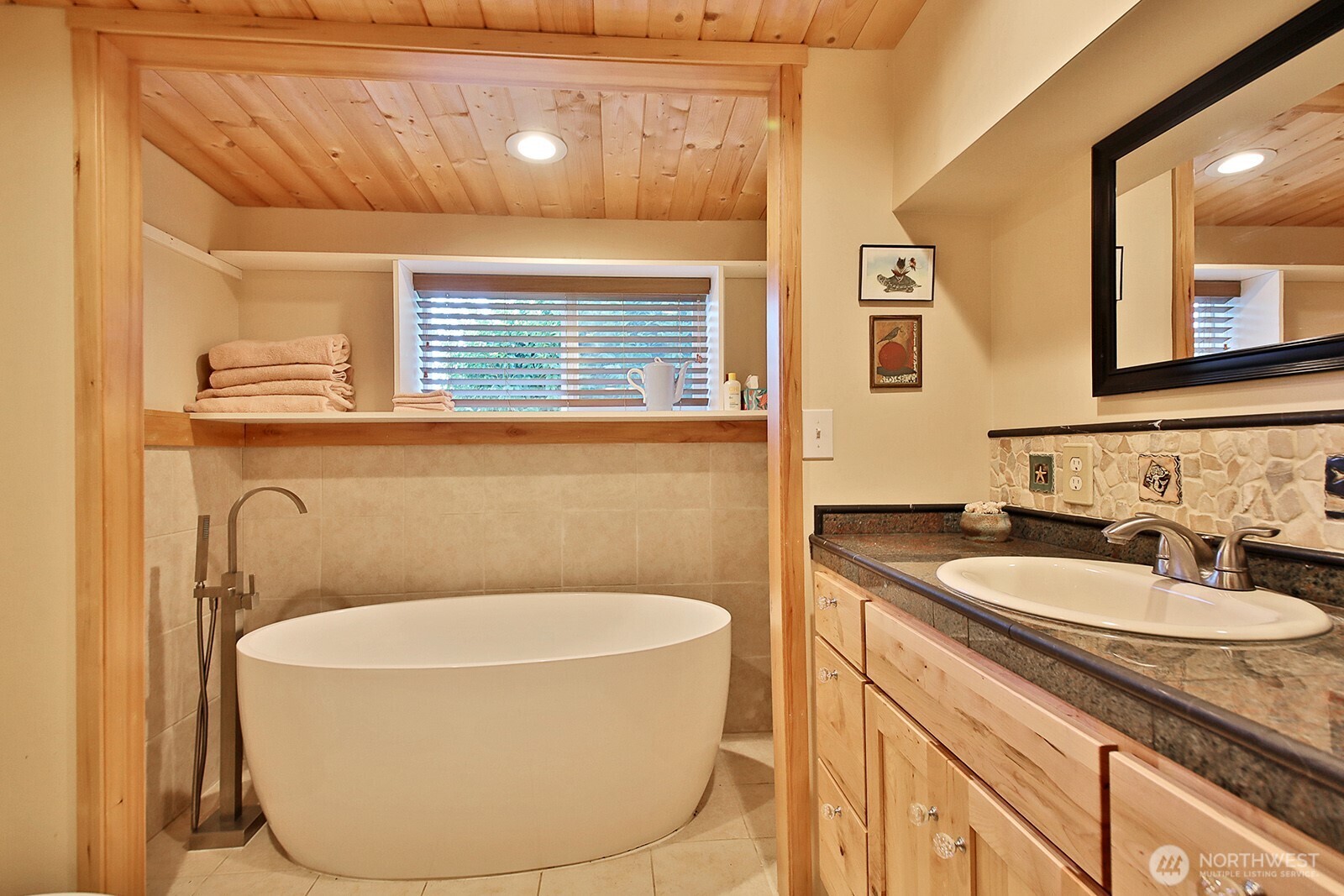 8121 Sandy Hook Terrace Clinton, WA 98236 - Photo 23 of 40 a bathroom with a granite countertop sink and a mirror