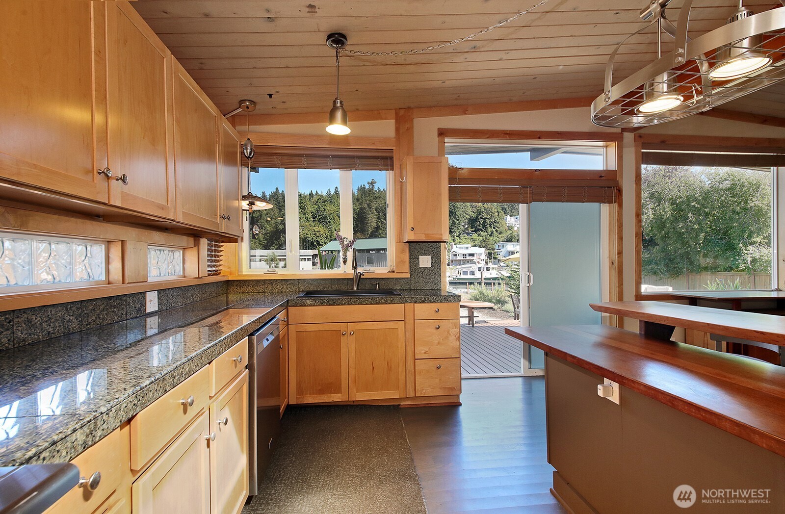 8121 Sandy Hook Terrace Clinton, WA 98236 - Photo 10 of 40 a kitchen with stainless steel appliances granite countertop a sink a stove and a wooden floor