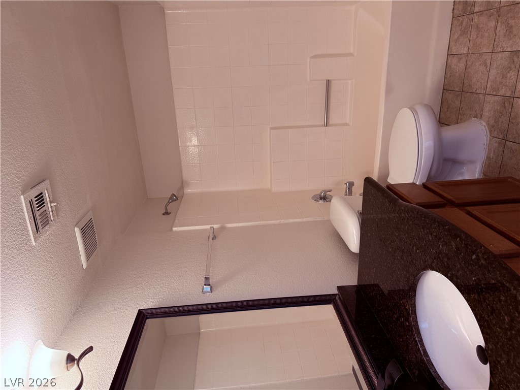 9325 West Desert Inn Road, Unit 260 Las Vegas, NV 89117 - Photo 22 of 42 Marble vanity and shower with sleek fixtures outfit this practical bathroom.