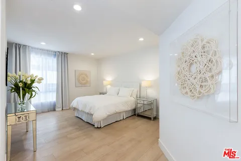 a bedroom with a bed and a potted plant