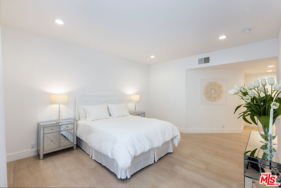 1164 Wellesley Avenue, Unit 101 Los Angeles, CA 90049 - Photo 12 of 25 a bedroom with a bed lamp and a potted plant