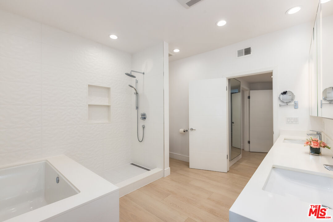 1164 Wellesley Avenue, Unit 101 Los Angeles, CA 90049 - Photo 14 of 25 a bathroom with a tub shower and sink