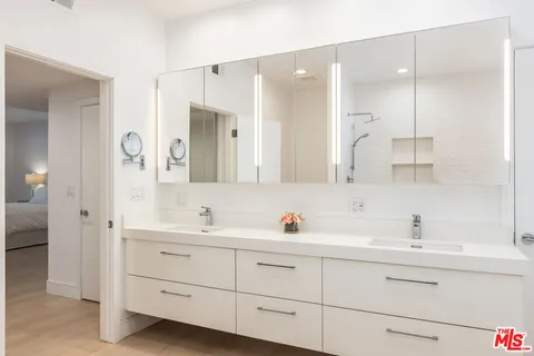 a bathroom with double sink and a mirror