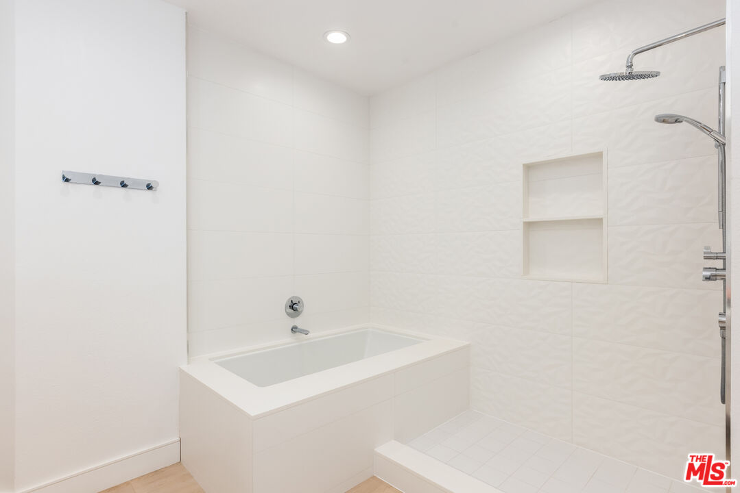 1164 Wellesley Avenue, Unit 101 Los Angeles, CA 90049 - Photo 16 of 25 a bathroom with a sink a shower and a mirror